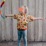 Ein spielendes Kind trägt das mitwachsendes T-Shirt für Kinder im Motiv Waldgewusel von der Marke Oktopulli