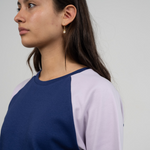 Seitenansicht einer Frau im fairen T-Shirt in Blau und Flieder von Oktopulli mit Unisex Schnitt aus Bio-Baumwolle
