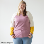 Eine Frau trägt den nachhaltigen Pullover für Erwachsene aus Bio-Baumwolle im Unisex-Schnitt in Flieder Gelb von Oktopulli