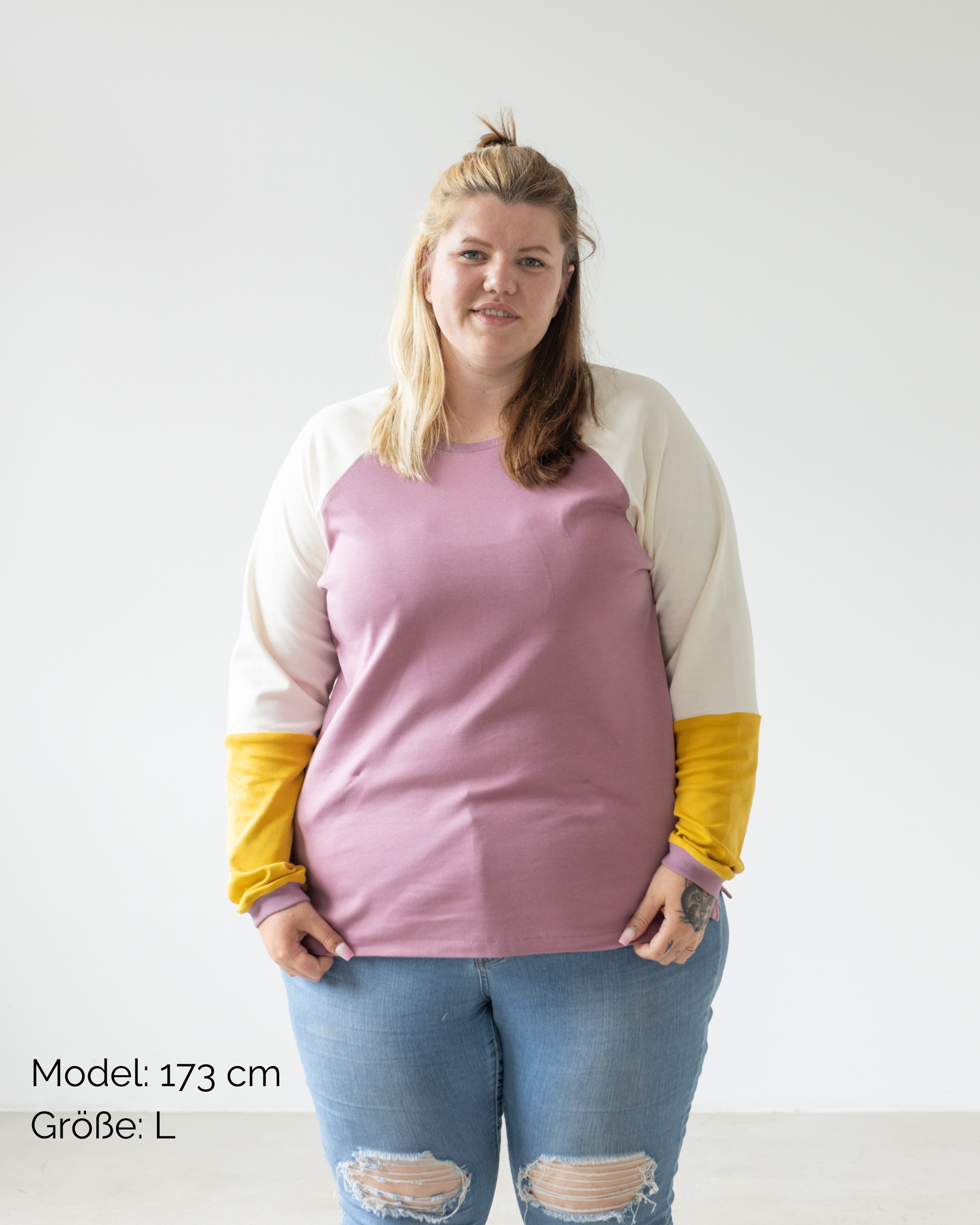 Eine Frau trägt den nachhaltigen Pullover für Erwachsene aus Bio-Baumwolle im Unisex-Schnitt in Flieder Gelb von Oktopulli