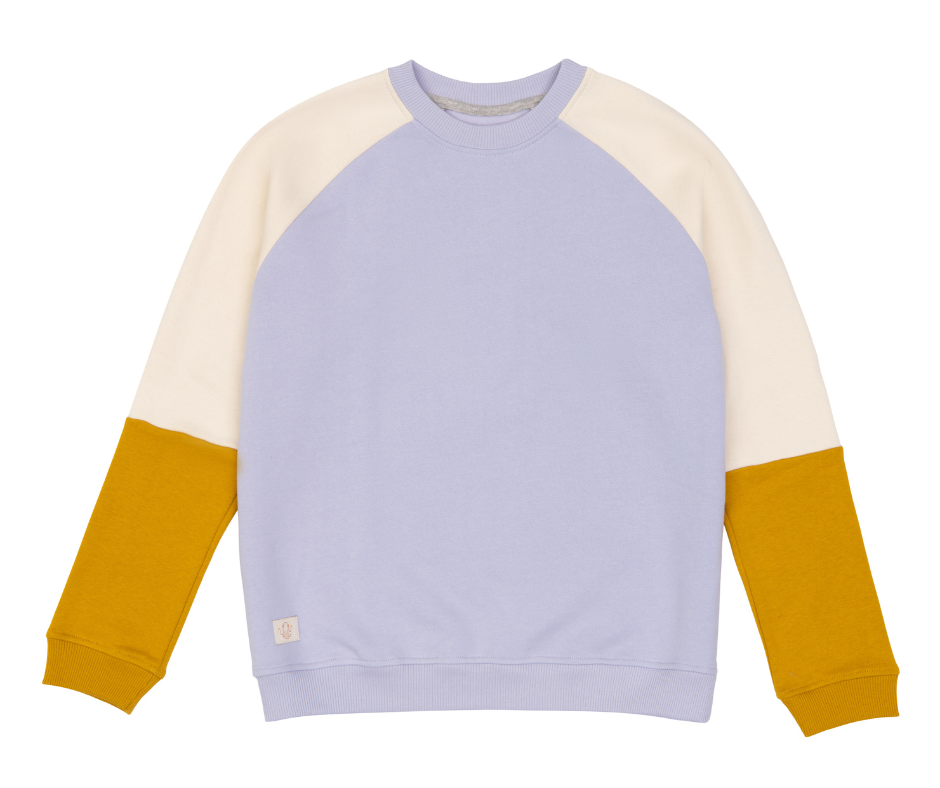 Raglan Erwachsenenpulli. Korpus fliederfarben. Ärmel zweiteilig, in der Mitte geteilt. Obere Farbe off-white, untere Farbe senfgelb. Bündchen an Hals und Saum fliederfarben, an den Ärmeln senfgelb.